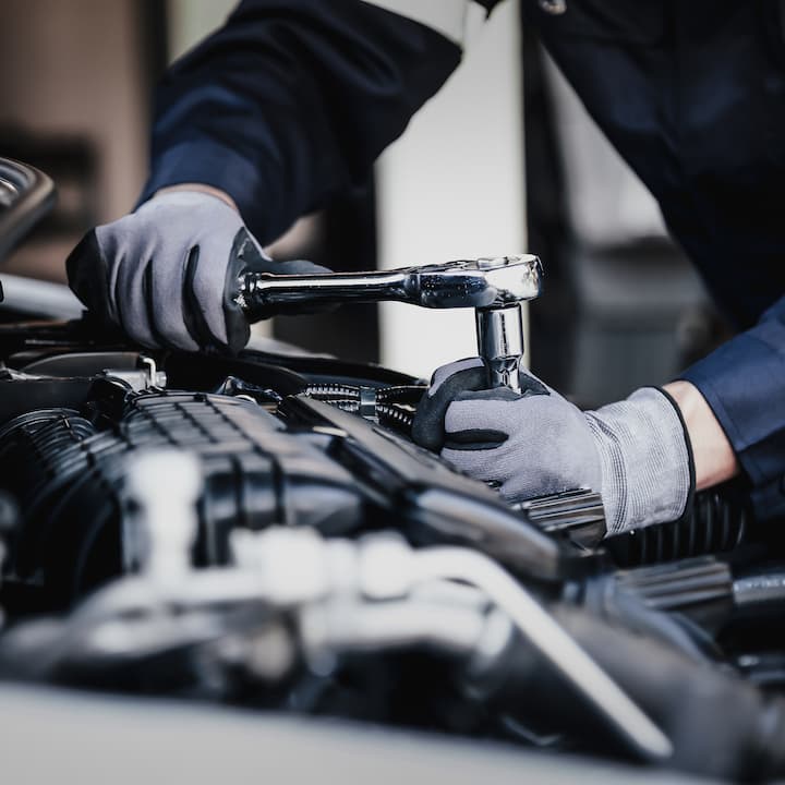 A car mechanic working on an engine | Services provided for Automotive Professionals